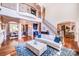 Bright, two-story living room featuring a white sofa, coffered ceilings, hardwood floors and staircase at 600 Beauhaven Ln, Waxhaw, NC 28173