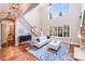 A bright living room boasts high ceilings, large windows, hardwood floors, and comfortable seating at 600 Beauhaven Ln, Waxhaw, NC 28173