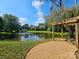 Scenic pond view showcases a tranquil setting with a charming pergola and fountain, enhancing the property's appeal at 600 Beauhaven Ln, Waxhaw, NC 28173