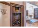 Custom wine cellar with built-in shelving and storage, with a glimpse into the living room at 600 Beauhaven Ln, Waxhaw, NC 28173