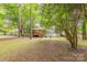 Private wooded backyard, with deck, patio, and lush green trees, providing a tranquil outdoor escape at 6418 Tivoli Ct, Charlotte, NC 28211