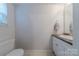 Neat bathroom featuring an oval mirror, toilet and a white sink with a vanity at 6418 Tivoli Ct, Charlotte, NC 28211