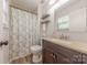 Bathroom features modern sink, vanity, a toilet, and shower with floral curtain at 6418 Tivoli Ct, Charlotte, NC 28211