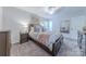Comfortable bedroom with a wooden bed frame, side tables and carpet at 6418 Tivoli Ct, Charlotte, NC 28211