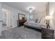 Bright bedroom with gray carpet, dark wood furniture, natural light, and en-suite bathroom access at 6418 Tivoli Ct, Charlotte, NC 28211