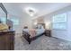 Cozy bedroom with dark wood furniture, carpeted floors, neutral walls, and natural light from windows at 6418 Tivoli Ct, Charlotte, NC 28211
