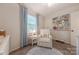 Bedroom features a white recliner, a side table and a window with blinds and curtains at 6418 Tivoli Ct, Charlotte, NC 28211