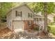 Two-story home featuring gray siding, brick accents, an attached garage, and a covered front porch with white railings at 6418 Tivoli Ct, Charlotte, NC 28211