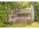 Charming two-story home with gray siding, brick accents, a welcoming front porch, and mature trees providing shade at 6418 Tivoli Ct, Charlotte, NC 28211