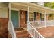 Close-up of a brick front porch featuring a teal door, house number, and hanging flower baskets at 6418 Tivoli Ct, Charlotte, NC 28211