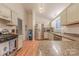 Open kitchen with stainless appliances, light cabinets, granite counters, and wood floors at 6418 Tivoli Ct, Charlotte, NC 28211