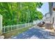 Landscaped backyard with a blue deck, patio, grill, and a white picket fence at 713 Torrey Pines Ln, Fort Mill, SC 29715
