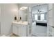 Bright bathroom with a white vanity, a large mirror, and an open doorway to the primary bedroom at 713 Torrey Pines Ln, Fort Mill, SC 29715