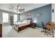 Spacious bedroom with a dark accent wall, ceiling fan, and ample natural light from multiple windows at 713 Torrey Pines Ln, Fort Mill, SC 29715
