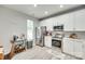 Well-lit kitchen featuring white cabinets, stainless steel appliances, and hardwood floors at 713 Torrey Pines Ln, Fort Mill, SC 29715