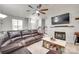 Comfortable living room showcasing a fireplace, ceiling fan, and a large sectional at 713 Torrey Pines Ln, Fort Mill, SC 29715