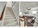 Inviting living room with a comfortable leather sofa, ceiling fan, and staircase to the upper level at 713 Torrey Pines Ln, Fort Mill, SC 29715