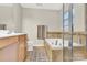 Bathroom featuring a relaxing soaking tub with tile surround, vanity, and glass-enclosed shower at 7339 Dover Mill Sw Dr, Concord, NC 28025