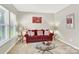 Bright living room with a comfortable red sofa, glass coffee table, and tasteful decor at 7339 Dover Mill Sw Dr, Concord, NC 28025