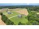 Aerial view shows the home on a spacious lot with surrounding trees and farmland at 7805 Crooked Creek Church Rd, Monroe, NC 28110