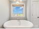Bathroom features a freestanding tub, window with shades, and modern fixtures at 7805 Crooked Creek Church Rd, Monroe, NC 28110