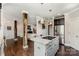 Open concept kitchen features a central island cooktop, stainless steel appliances, and modern lighting at 7805 Crooked Creek Church Rd, Monroe, NC 28110