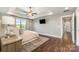Bright main bedroom with tray ceiling, fan, large window, mounted TV, and ensuite bathroom at 7805 Crooked Creek Church Rd, Monroe, NC 28110