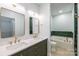 Well-lit bathroom featuring double sinks, a large mirror and a soaking tub with tile backsplash at 795 Peninsula Dr, Davidson, NC 28036