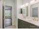 Well-lit bathroom featuring double sinks, a large mirror and access to the bedroom at 795 Peninsula Dr, Davidson, NC 28036