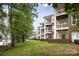 Multi-story apartment building featuring balconies, brick accents, and manicured lawn at 795 Peninsula Dr, Davidson, NC 28036