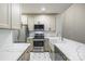 Bright kitchen with stainless steel appliances, patterned backsplash, white cabinetry, and marble countertops at 795 Peninsula Dr, Davidson, NC 28036