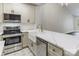Modern kitchen with stainless steel appliances, white cabinets, and an island countertop at 795 Peninsula Dr, Davidson, NC 28036
