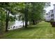 Apartment landscaping featuring large trees, green grass, and lake views at 795 Peninsula Dr, Davidson, NC 28036
