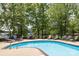 Community swimming pool featuring lounge chairs and lush, mature trees at 795 Peninsula Dr, Davidson, NC 28036