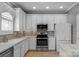 Well-lit kitchen features white cabinets, stainless steel appliances, and tile backsplash at 8232 Sunset Hill Rd # Th88, Waxhaw, NC 28173