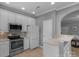 Bright kitchen with stainless steel appliances, white cabinets, and breakfast bar at 8232 Sunset Hill Rd # Th88, Waxhaw, NC 28173