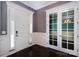 Elegant foyer featuring dark hardwood floors, white wainscoting, and a front door with sidelights at 8402 Aspen Ct, Charlotte, NC 28227