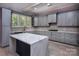 Elegant kitchen with gray cabinetry, gold hardware, a center island, and natural light from the windows at 8402 Aspen Ct, Charlotte, NC 28227
