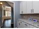 Bright kitchen nook featuring white cabinets, granite counters, and a view into an elegant dining area at 8402 Aspen Ct, Charlotte, NC 28227
