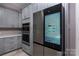Modern kitchen with built-in microwave/oven and smart stainless steel refrigerator with screen at 8402 Aspen Ct, Charlotte, NC 28227