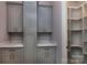 Well-organized laundry room with gray cabinets, stylish gold hardware, and a convenient walk-in storage area at 8402 Aspen Ct, Charlotte, NC 28227
