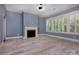 Bright living room with a fireplace, large windows, and light hardwood floors at 8402 Aspen Ct, Charlotte, NC 28227