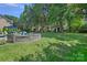 Private backyard features stone fire pit area, lush lawn, and wooded surroundings at 9427 Gilpatrick Ln # 5, Huntersville, NC 28078