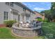 Backyard patio area with a stone fire pit, seating, and manicured landscaping at 9427 Gilpatrick Ln # 5, Huntersville, NC 28078