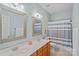 Bathroom with dual sinks, wood cabinets, vanity, mirrors and striped shower curtain at 9427 Gilpatrick Ln # 5, Huntersville, NC 28078