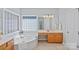 Bright bathroom with a large tub, tiled floors, and wood vanity with a sink and mirror at 9427 Gilpatrick Ln # 5, Huntersville, NC 28078