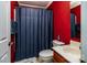 Vibrant red bathroom with blue shower curtain and classic white fixtures at 958 Hillard Ln, Lincolnton, NC 28092