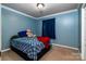 Cozy bedroom with blue walls, bed with patterned bedding, and plush teddy bear at 958 Hillard Ln, Lincolnton, NC 28092