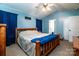 A charming bedroom features blue walls, natural wood furniture, and a ceiling fan at 958 Hillard Ln, Lincolnton, NC 28092