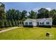Charming single-story home featuring a spacious front lawn, a driveway, blue shutters, and mature trees at 958 Hillard Ln, Lincolnton, NC 28092